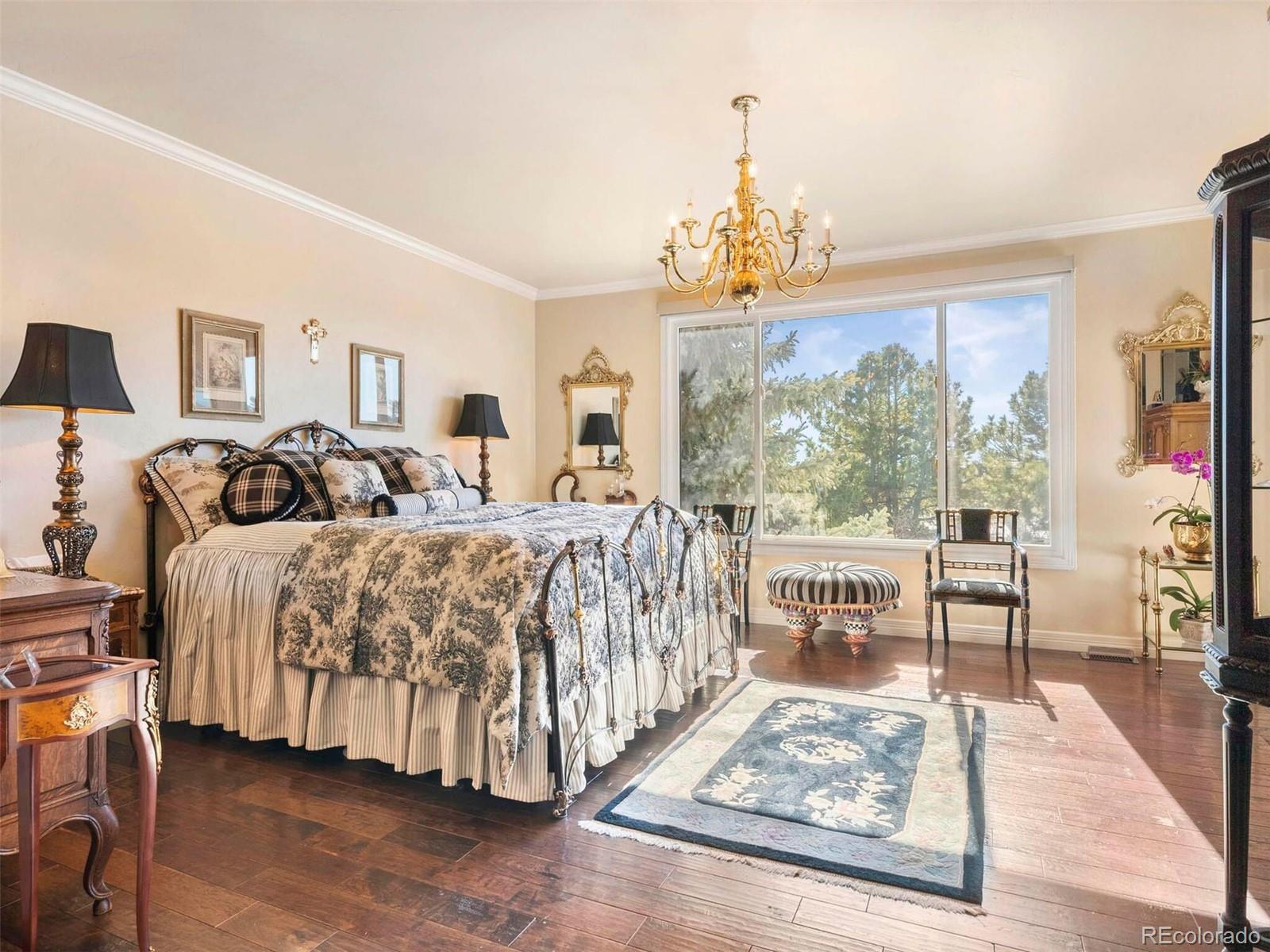 2124 Ridge Plaza Drive Castle Rock, CO 80108 - Photo 25 of 50 a bedroom with a bed and a chandelier