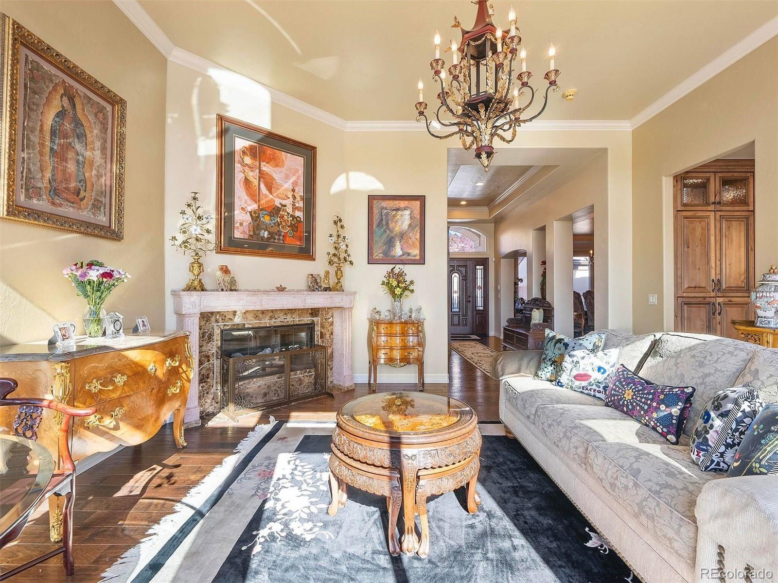 2124 Ridge Plaza Drive Castle Rock, CO 80108 - Photo 8 of 50 a living room with fireplace furniture and a chandelier