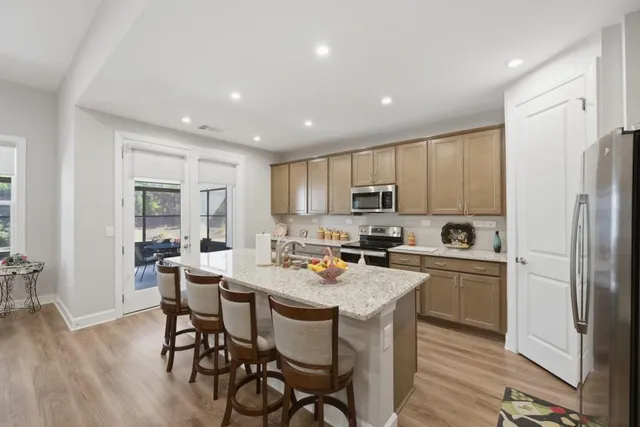 a kitchen with stainless steel appliances granite countertop a sink stove and refrigerator