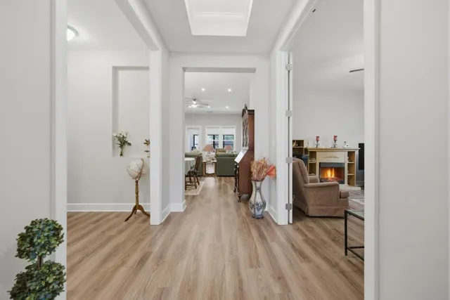 a dining room with wooden floor a chandelier a wooden table and chairs