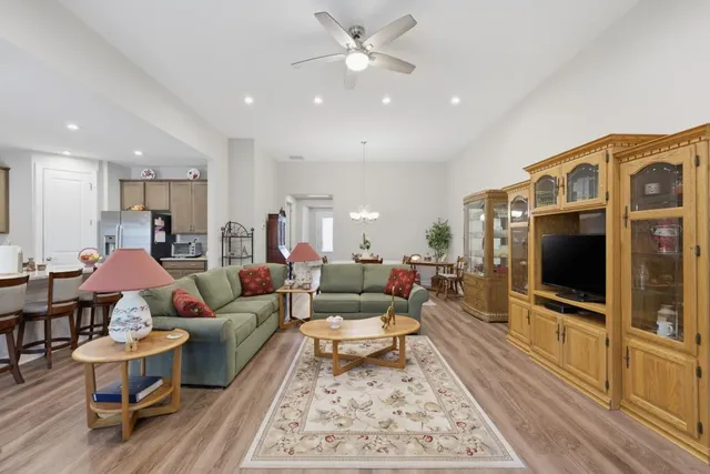 a living room with furniture kitchen view and a chandelier