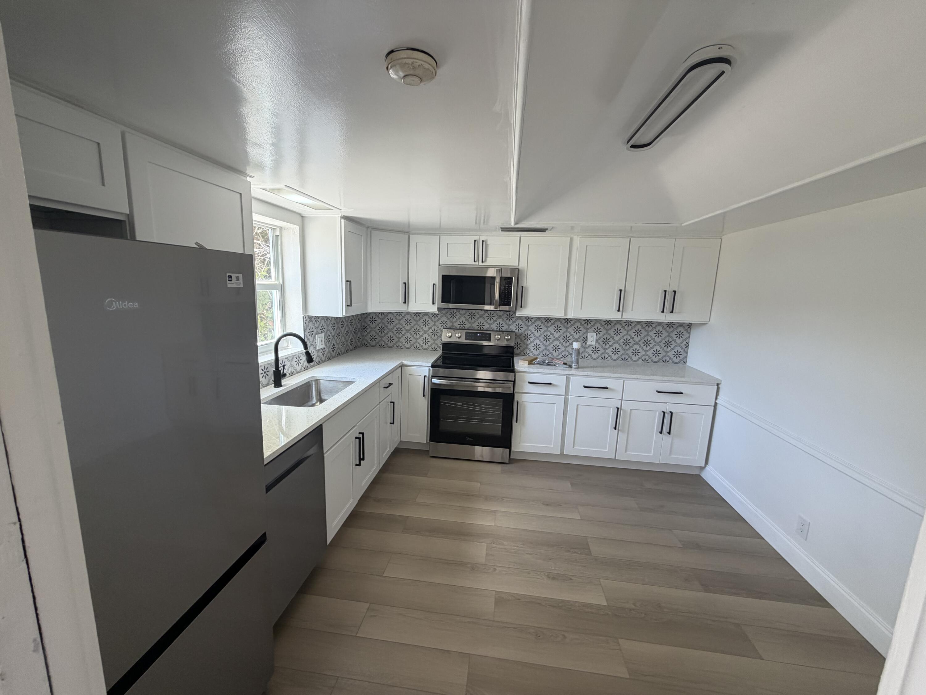 1216 Surf Road Singer Island, FL 33404 - Photo 2 of 15 a large kitchen with cabinets stainless steel appliances and a counter space