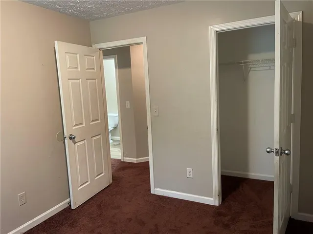 an empty room with closet and wooden floor