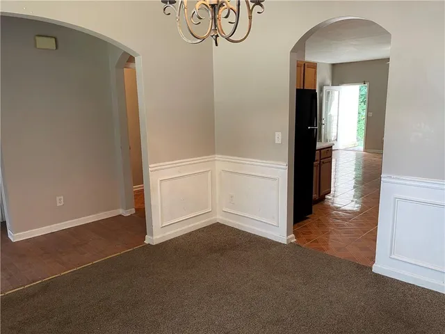 an empty room with wooden floor and cabinet