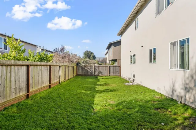 a view of backyard with wooden fence