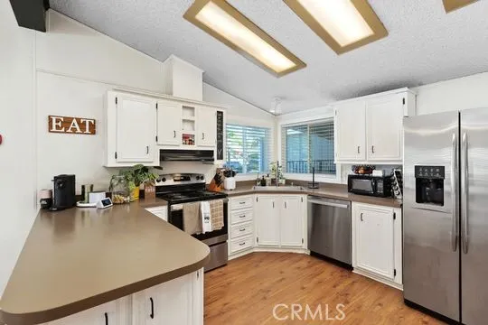 a kitchen with stainless steel appliances a stove sink microwave and cabinets