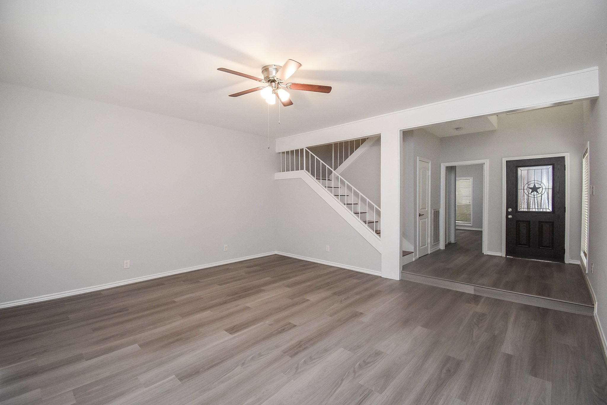 201 Vanderpool Lane, Unit 113 Houston, TX 77024 - Photo 5 of 45 an empty room with wooden floor fan and windows