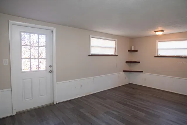 a view of a backyard with plants and large trees