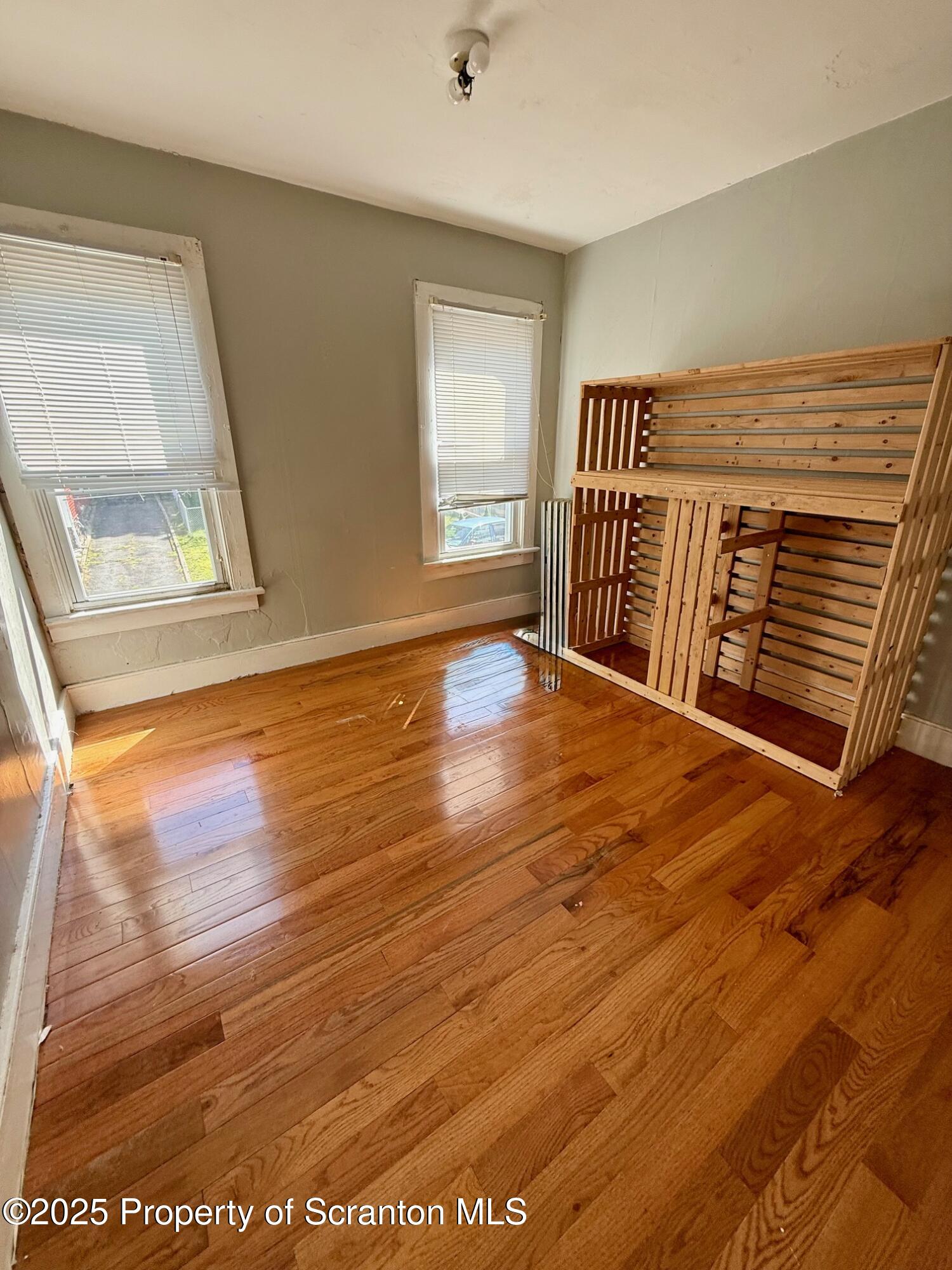 97 Washington Street Carbondale, PA 18407 - Photo 11 of 18 a view of an empty room with wooden floor and a window