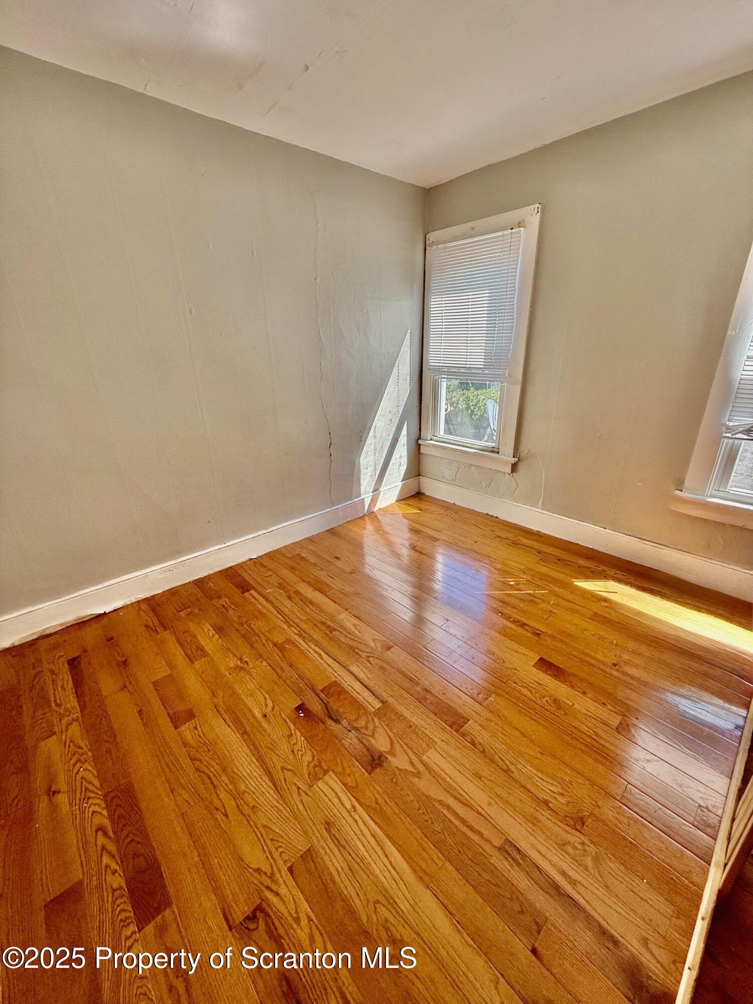 97 Washington Street Carbondale, PA 18407 - Photo 10 of 18 a view of an empty room with wooden floor and a window