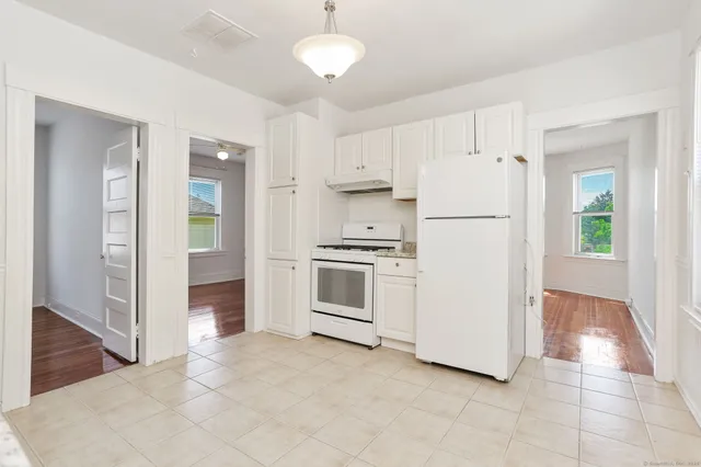 a kitchen with white cabinets and white appliances