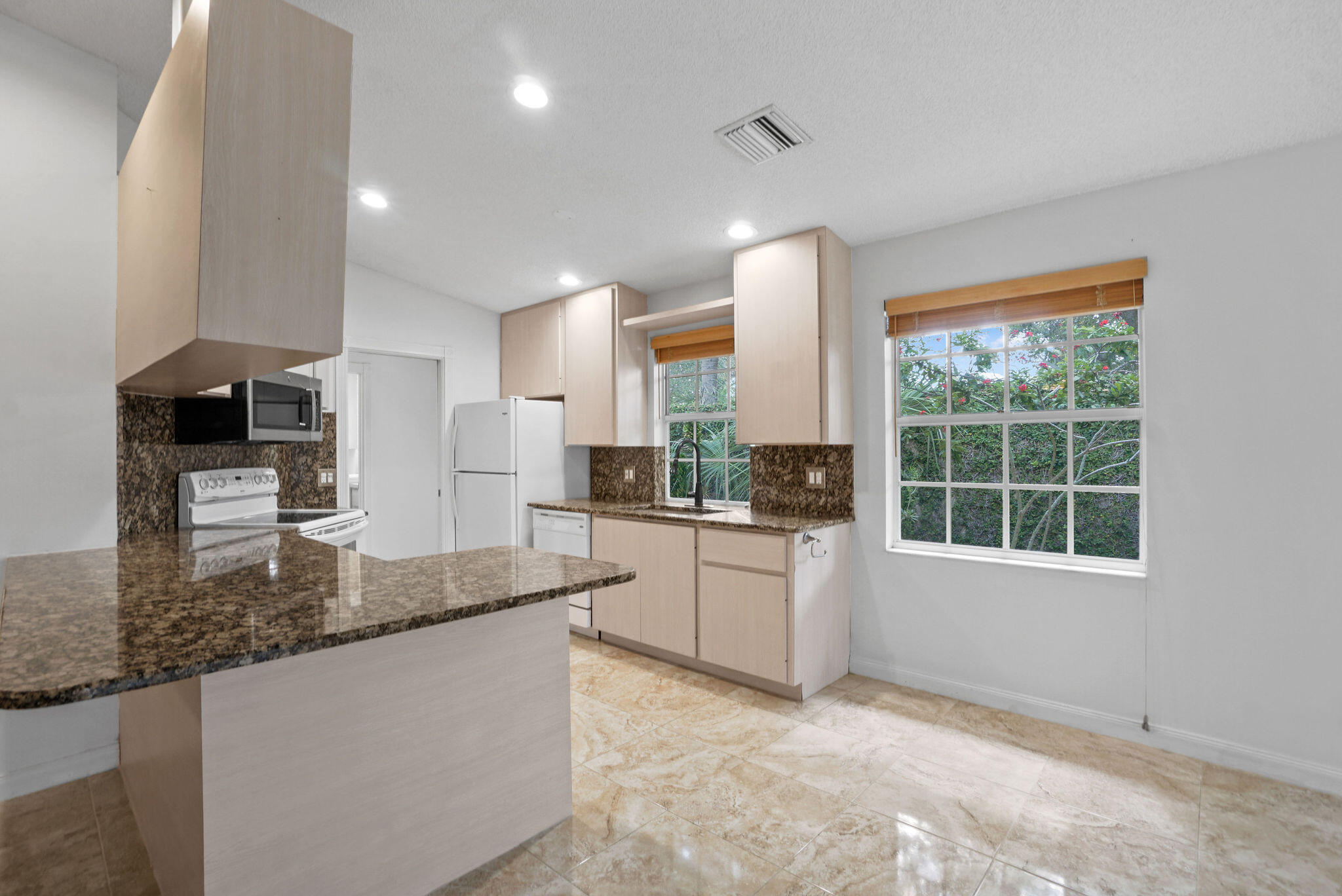 198 Brier Circle Jupiter, FL 33458 - Photo 15 of 38 a kitchen with stainless steel appliances granite countertop a stove a sink and a refrigerator