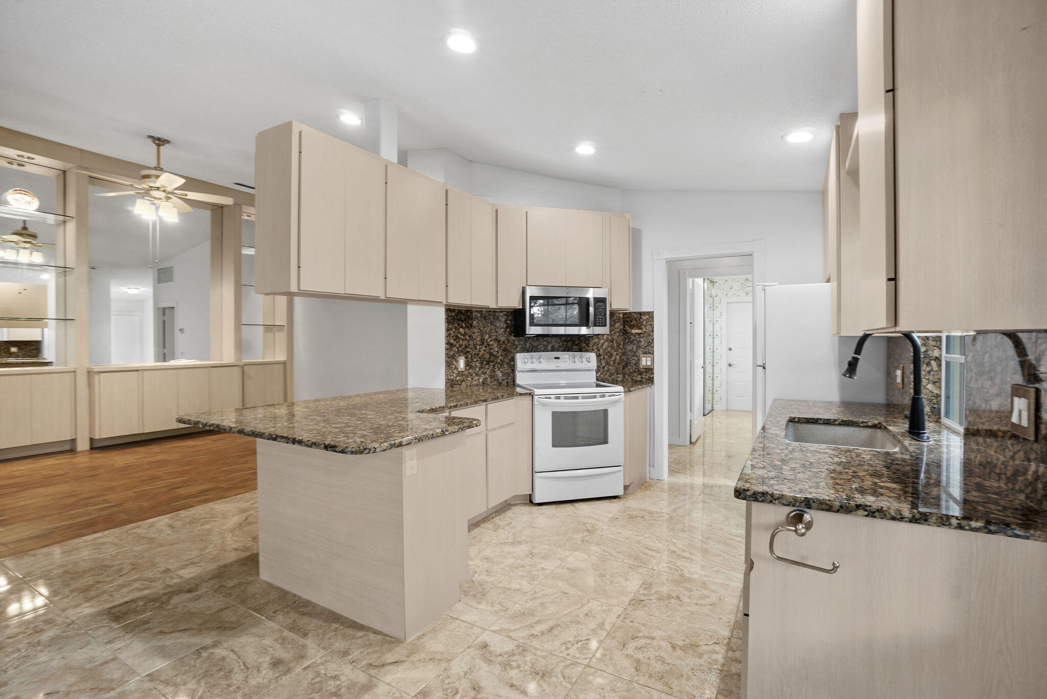 198 Brier Circle Jupiter, FL 33458 - Photo 17 of 38 a kitchen with stainless steel appliances granite countertop a sink stove and refrigerator