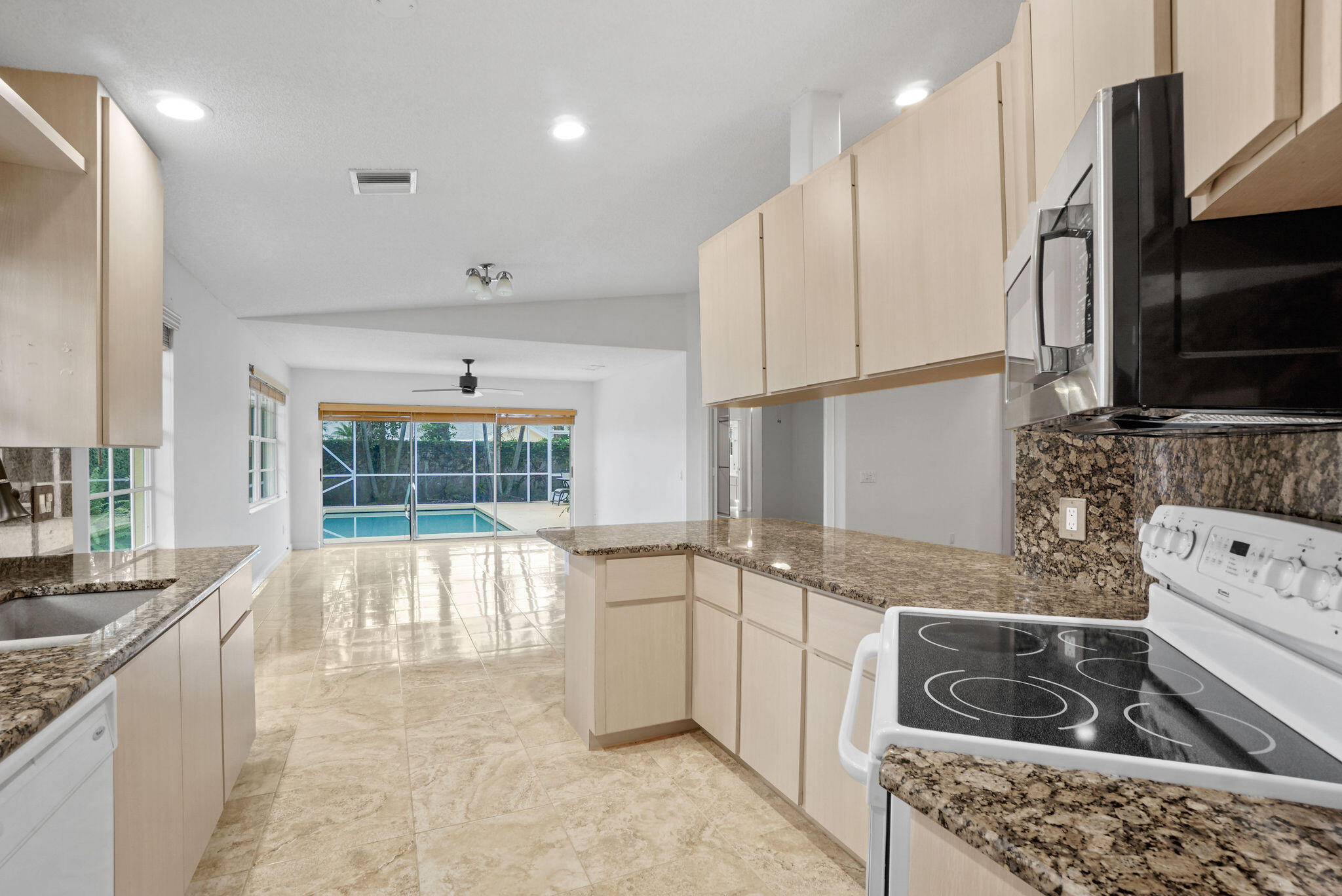 198 Brier Circle Jupiter, FL 33458 - Photo 19 of 38 a large kitchen with stainless steel appliances granite countertop a sink and a stove