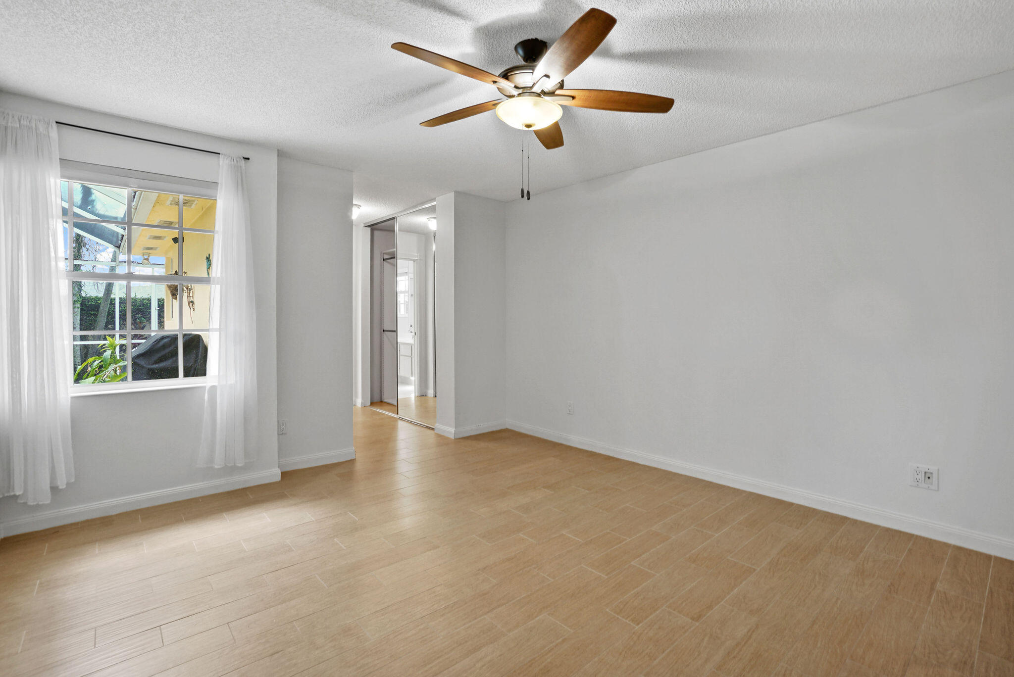 198 Brier Circle Jupiter, FL 33458 - Photo 21 of 38 an empty room with windows and fan