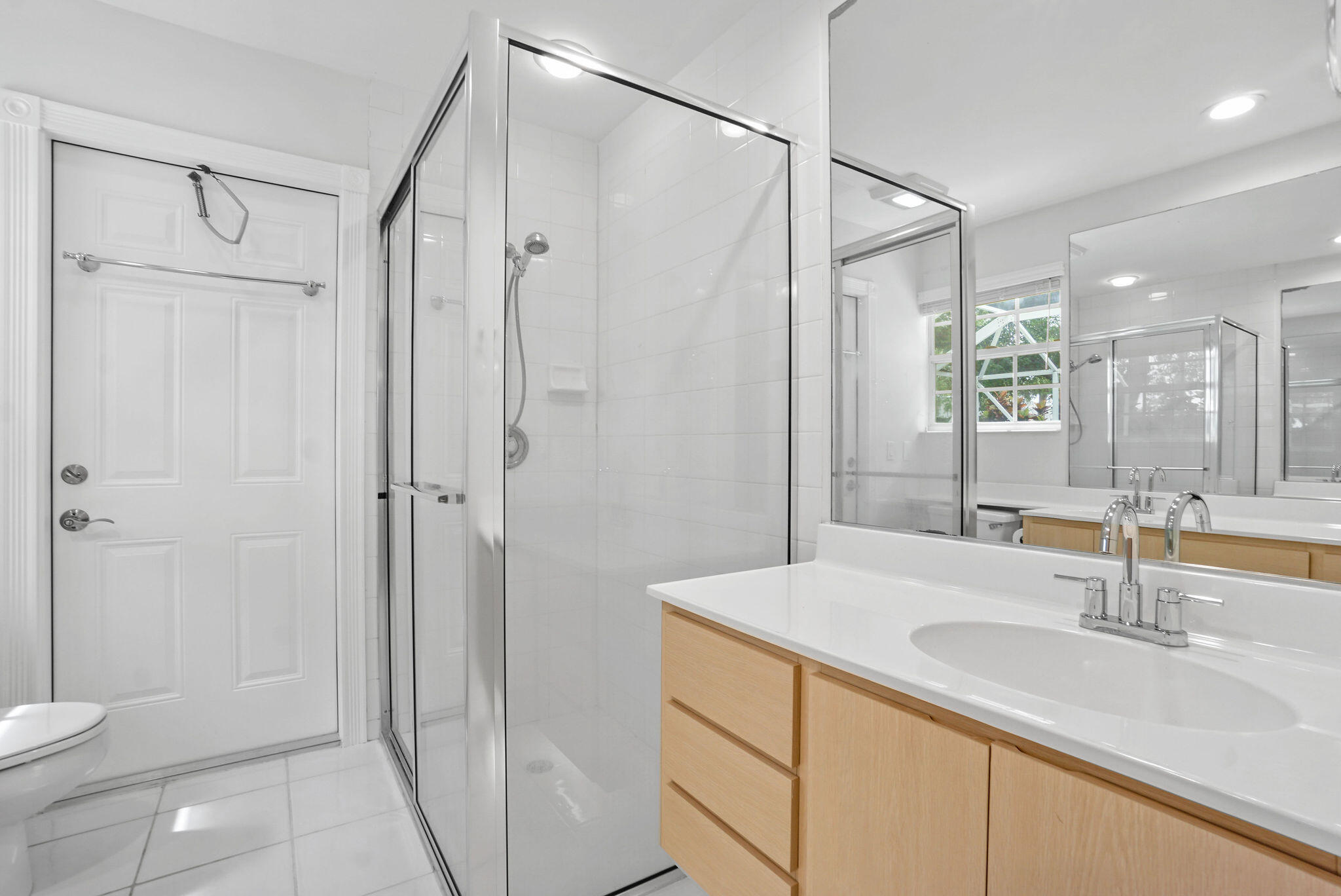 198 Brier Circle Jupiter, FL 33458 - Photo 27 of 38 a bathroom with a shower sink vanity and mirror