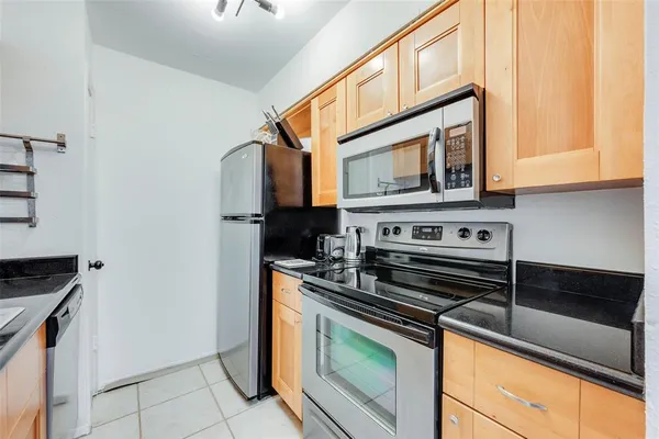 a kitchen with stainless steel appliances granite countertop a stove and a microwave