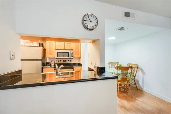 a kitchen with a table chairs and a refrigerator