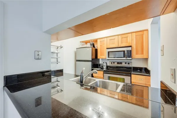 a kitchen with stainless steel appliances a stove microwave and sink