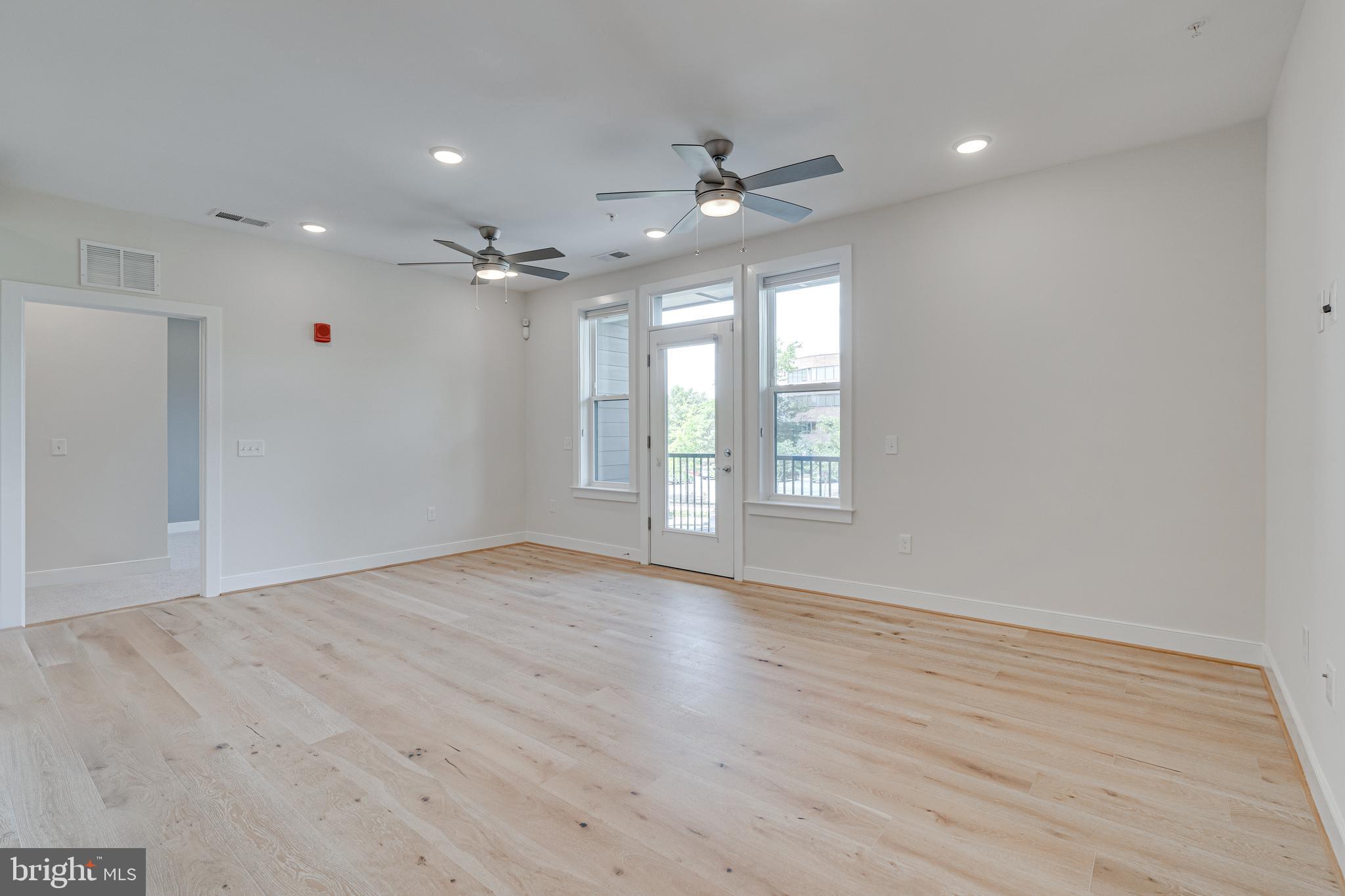 11200 Reston Station Boulevard, Unit 207 Reston, VA 20190 - Photo 10 of 40 an empty room with wooden floor fan and windows