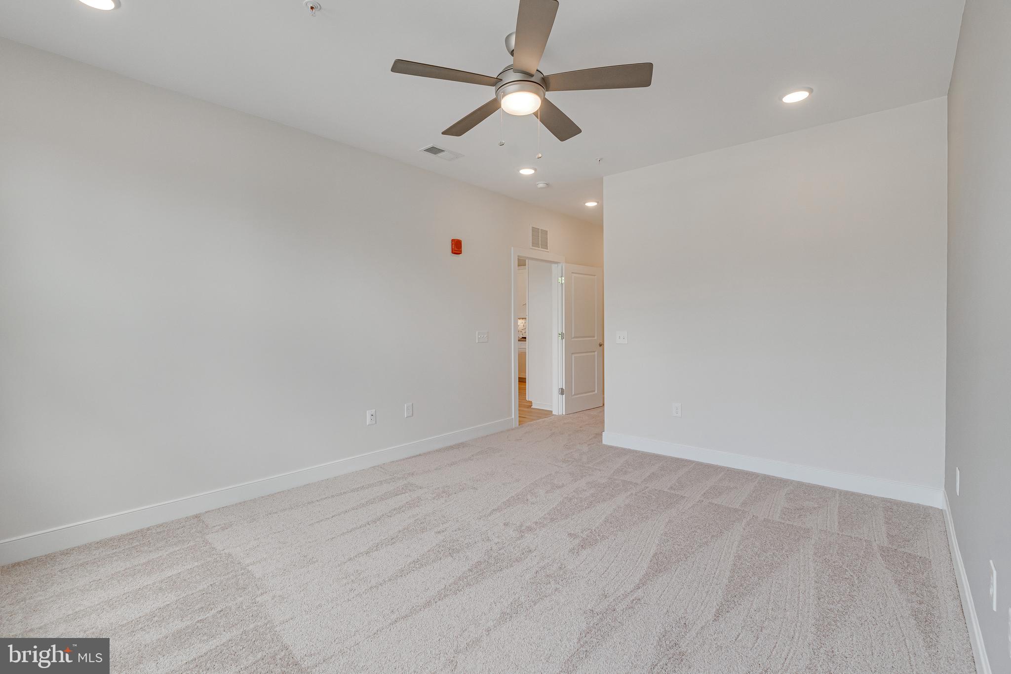 11200 Reston Station Boulevard, Unit 207 Reston, VA 20190 - Photo 15 of 40 en empty room with ceiling fan and window