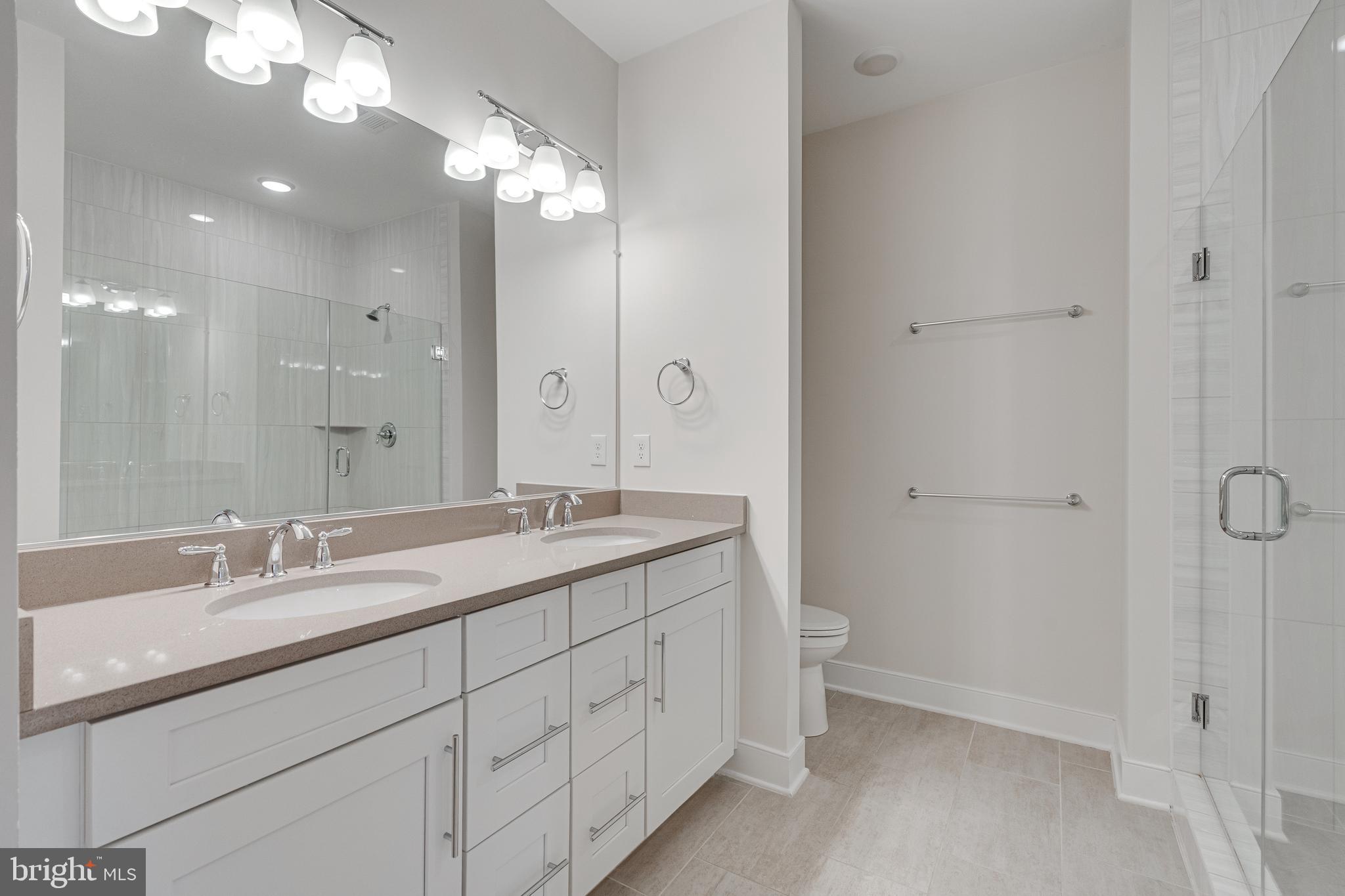11200 Reston Station Boulevard, Unit 207 Reston, VA 20190 - Photo 17 of 40 a bathroom with a double vanity sink and a mirror