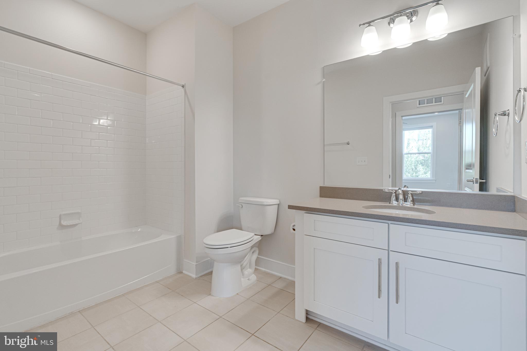 11200 Reston Station Boulevard, Unit 207 Reston, VA 20190 - Photo 22 of 40 a bathroom with a granite countertop toilet a sink and a bathtub