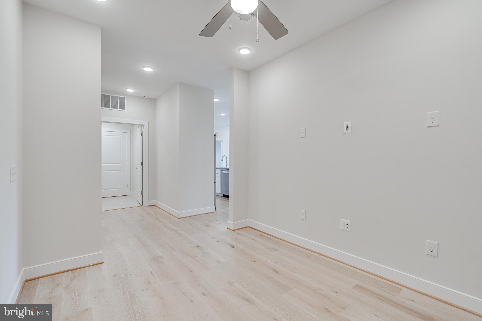 11200 Reston Station Boulevard, Unit 207 Reston, VA 20190 - Photo 25 of 40 an empty room with a hallway and a chandelier fan