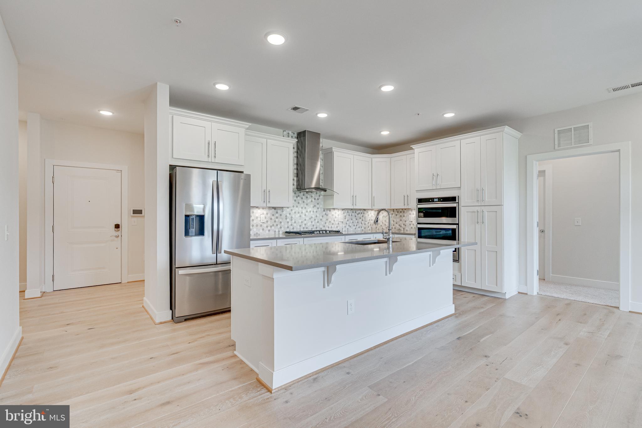 11200 Reston Station Boulevard, Unit 207 Reston, VA 20190 - Photo 4 of 40 a kitchen with stainless steel appliances granite countertop a refrigerator and a stove top oven