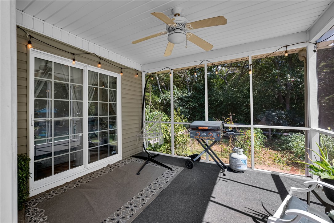 247 Clardy Road Pelzer, SC 29669 - Photo 21 of 34 Sliding doors open to a screened porch overlooking a wooded backyard setting.