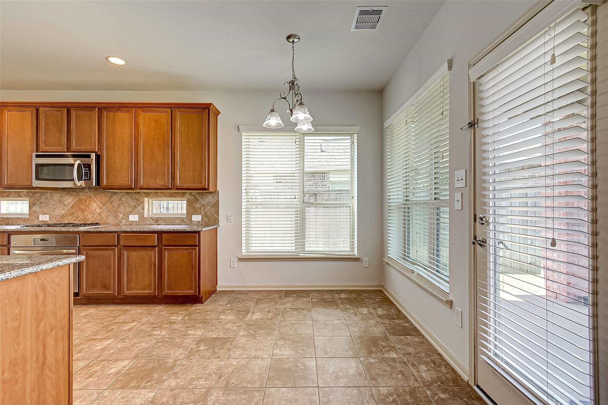 79 West Lasting Spring Circle Spring, TX 77389 - Photo 19 of 48 a large kitchen with kitchen island granite countertop a stove a sink and a granite counter top