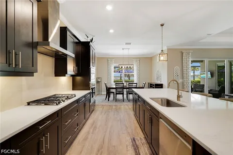 a kitchen with stainless steel appliances granite countertop a sink a stove and a wooden floors
