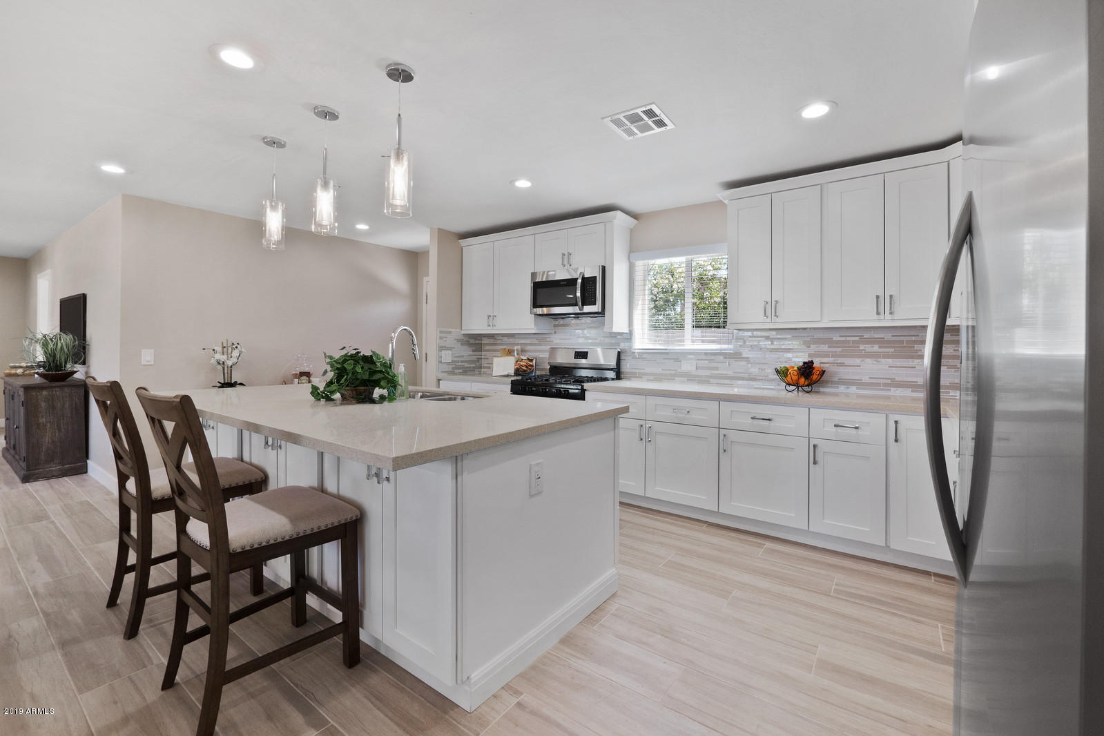 3351 North Randolph Road Phoenix, AZ 85014 - Photo 13 of 47 a kitchen with stainless steel appliances granite countertop a table chairs sink refrigerator and microwave