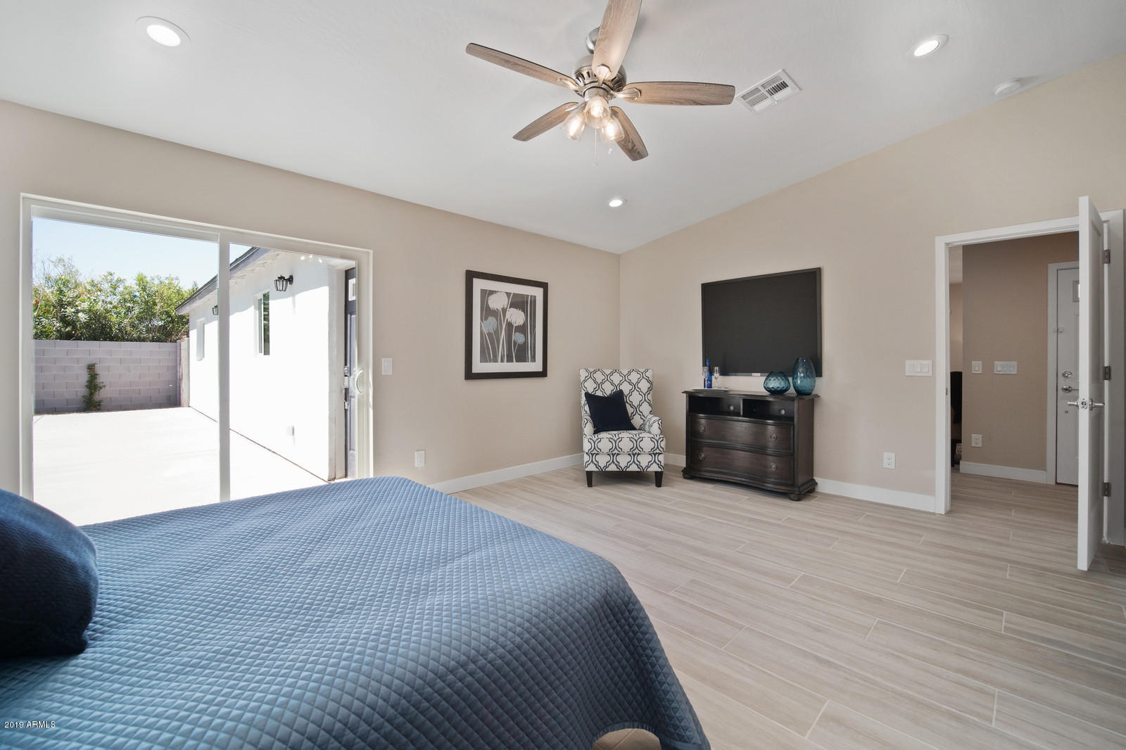 3351 North Randolph Road Phoenix, AZ 85014 - Photo 17 of 47 a spacious bedroom with a bed a chandelier and a flat screen television