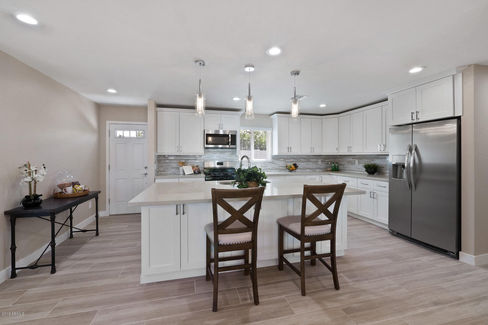 3351 North Randolph Road Phoenix, AZ 85014 - Photo 4 of 47 a kitchen with stainless steel appliances granite countertop a table chairs sink refrigerator and cabinets