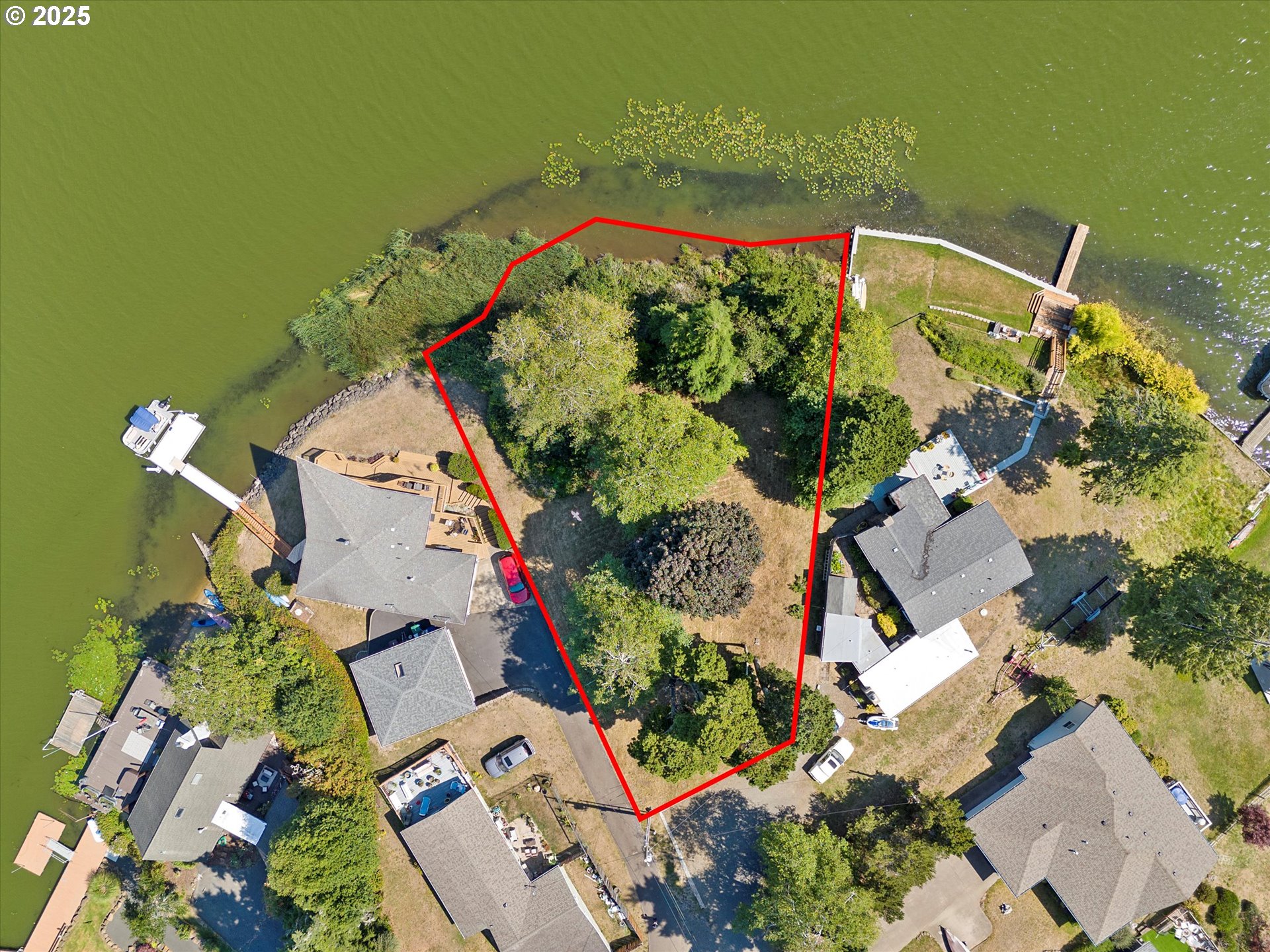 an aerial view of a house with a yard and lake view
