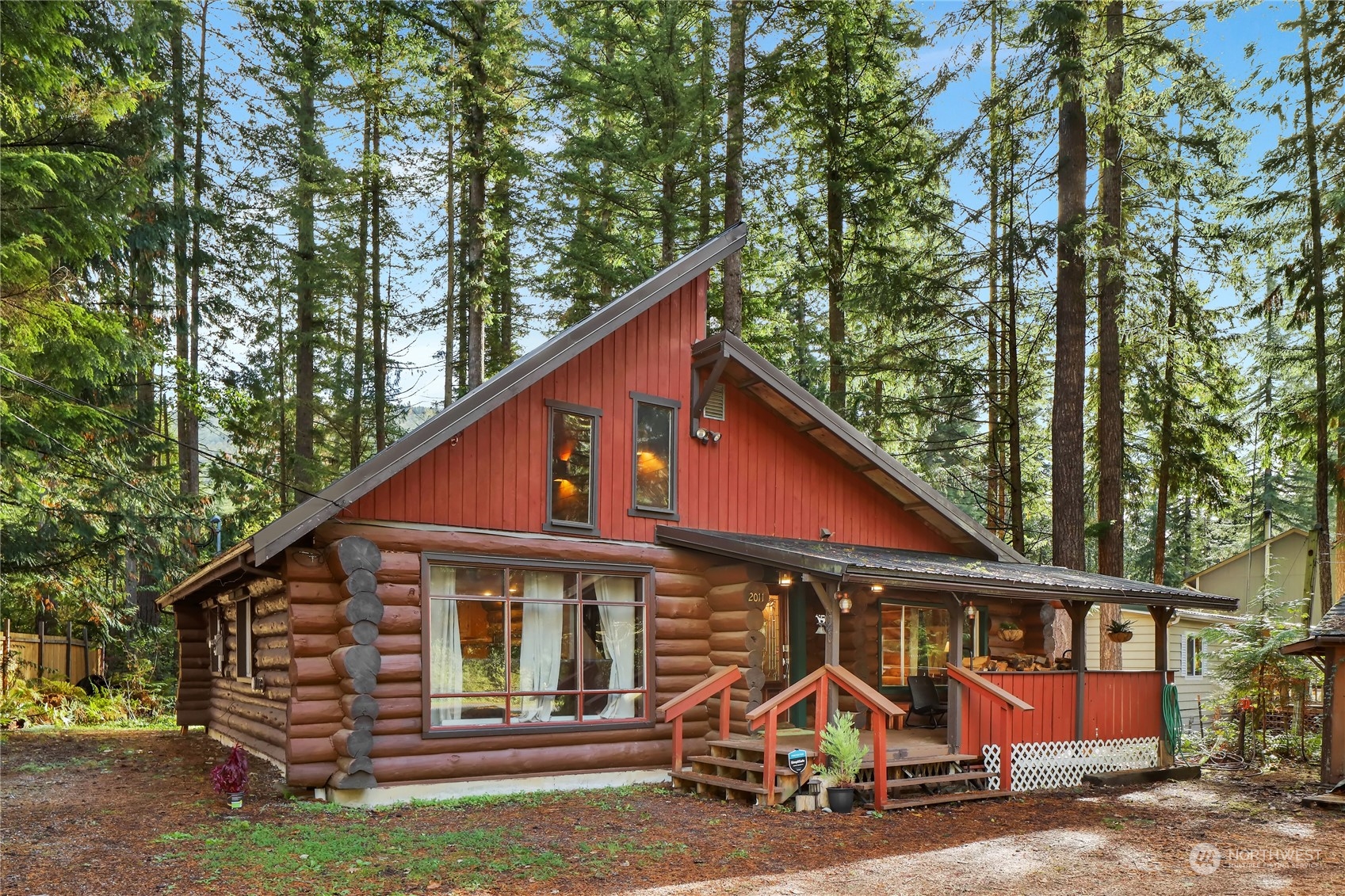 a view of small white house with large windows and a yard
