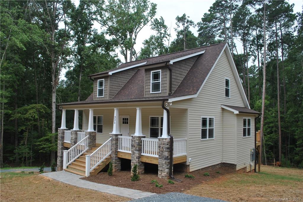a front view of house with yard and trees in the background