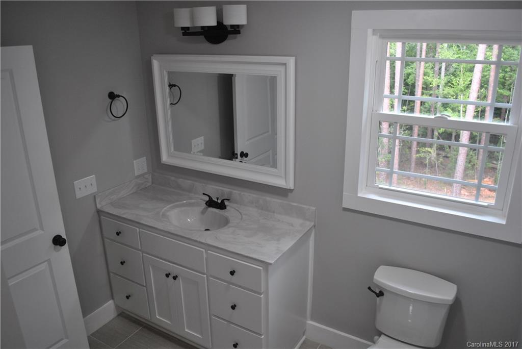 335 Creswell Road, Unit 1011 Mount Gilead, NC 27306 - Photo 13 of 18 a bathroom with a toilet sink and mirror