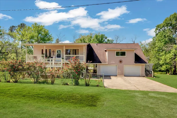 a front view of house with yard and trees in the background