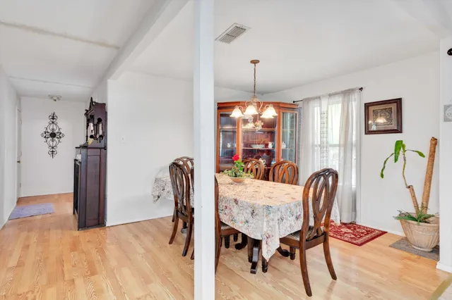 a view of a dining room with furniture and chandelier