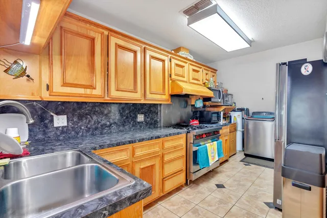 a kitchen with stainless steel appliances granite countertop a stove and cabinets