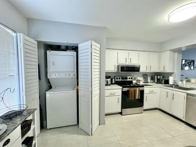 a kitchen with cabinets stainless steel appliances and a window
