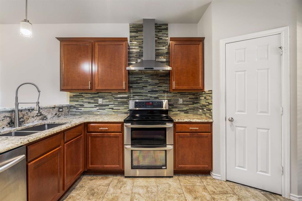 10969 Colonial Heights Lane Fort Worth, TX 76179 - Photo 8 of 34 a kitchen with stainless steel appliances granite countertop a stove and a sink