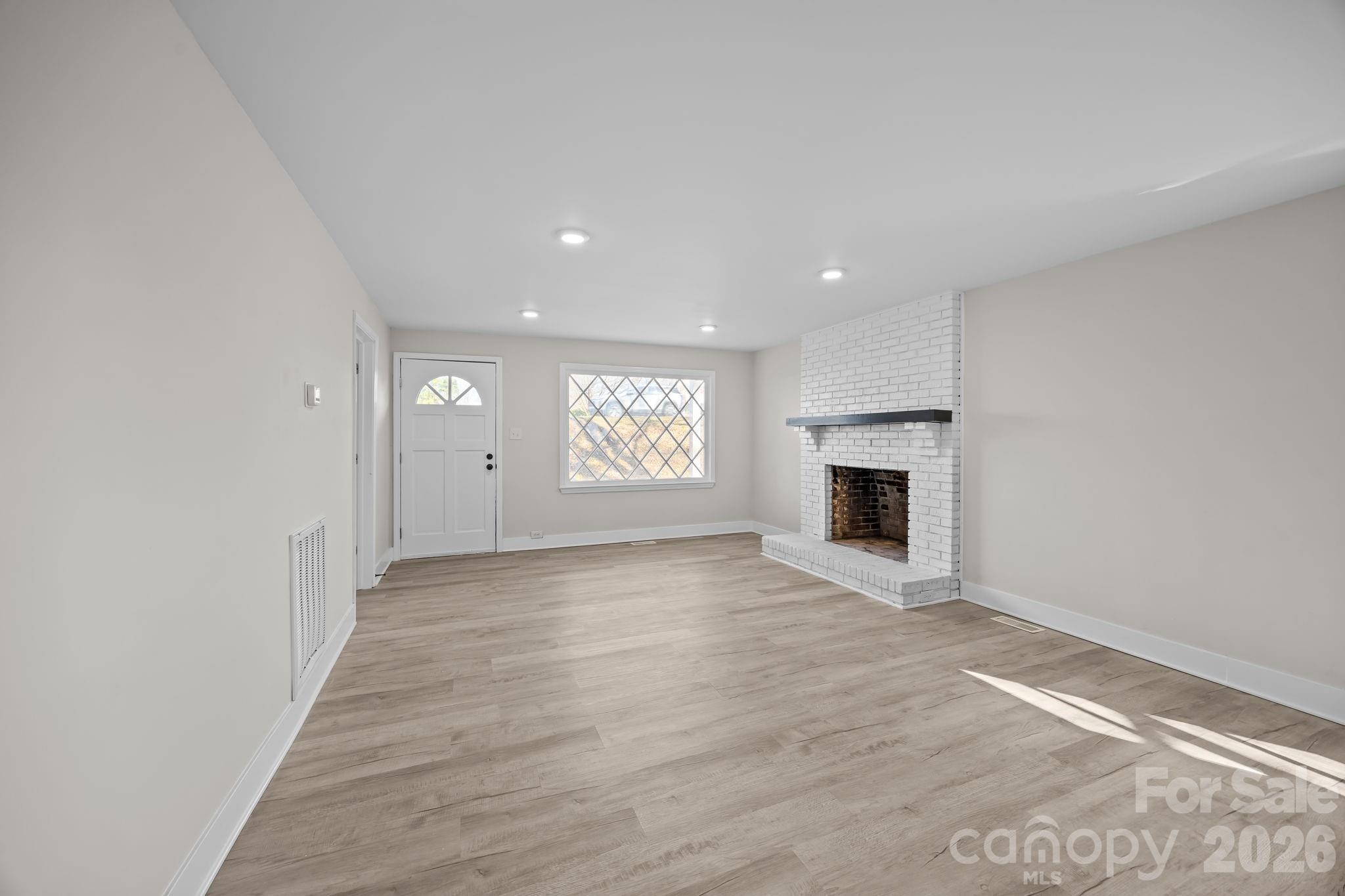 511 East Trade Street Dallas, NC 28034 - Photo 6 of 16 a view of an empty room with a fireplace and a window