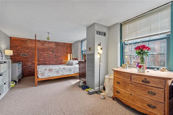 a bedroom with a bed dresser and a window