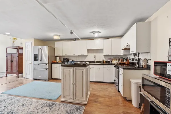 a kitchen with stainless steel appliances granite countertop a refrigerator sink and stove