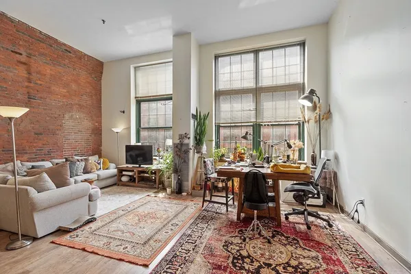 a living room with furniture a rug and a window