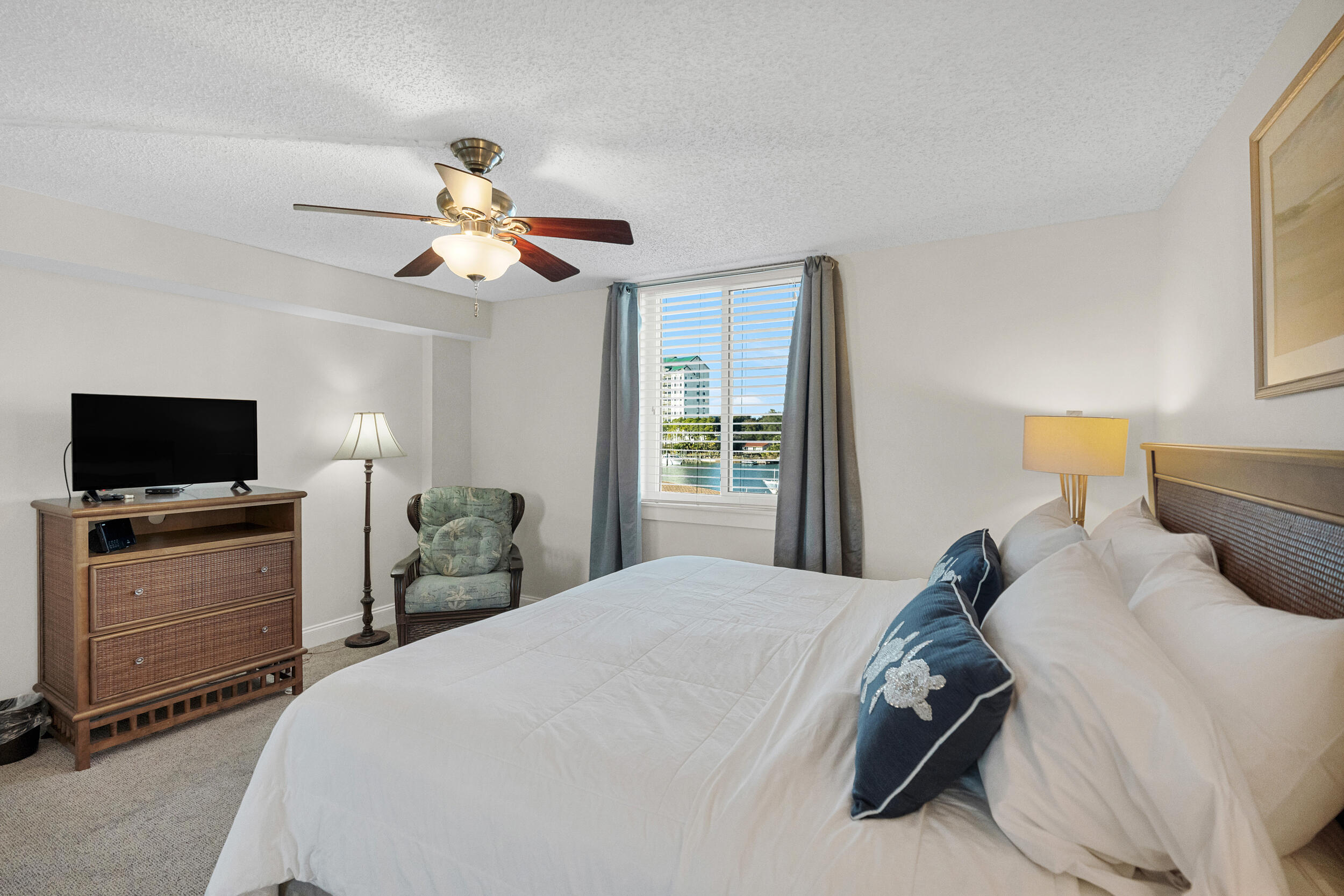 30 Moreno Point Road, Unit 303A Destin, FL 32541 - Photo 16 of 34 a bedroom with a bed and a flat screen tv