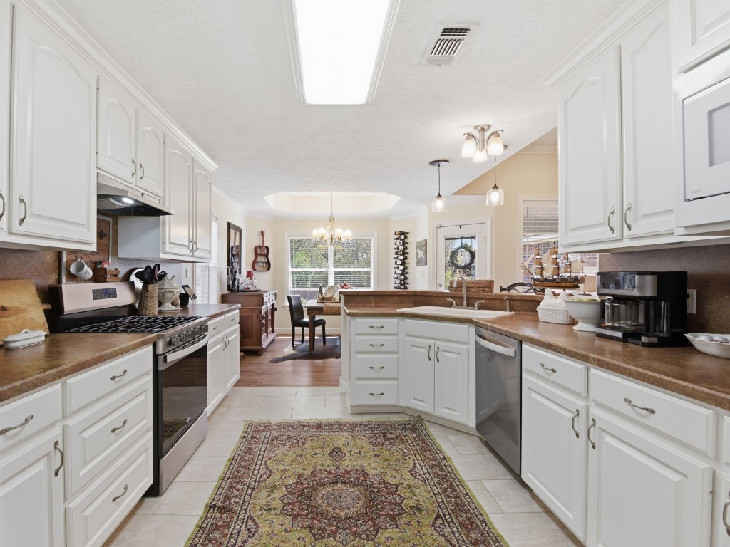 232 North Dixie Street Brenham, TX 77833 - Photo 17 of 41 This kitchen features a spacious layout with white cabinetry, and ample counter space. The design includes a cozy breakfast nook with large windows for natural light.